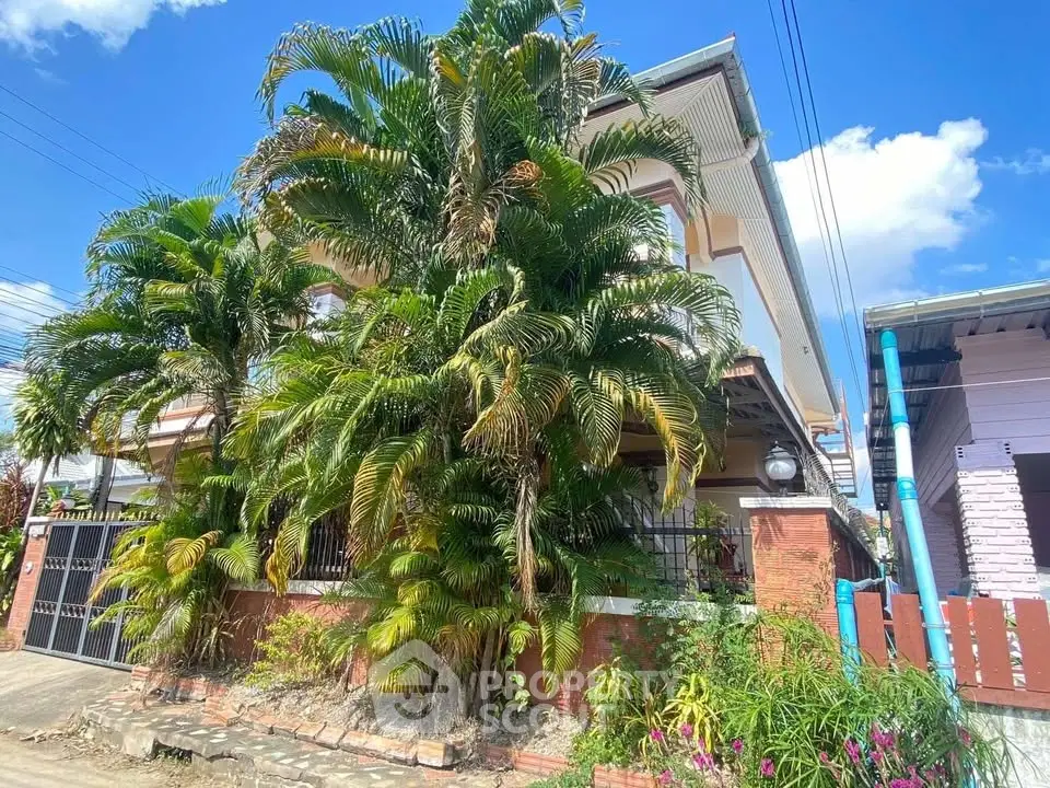 Charming tropical home with lush greenery and vibrant exterior, perfect for serene living.