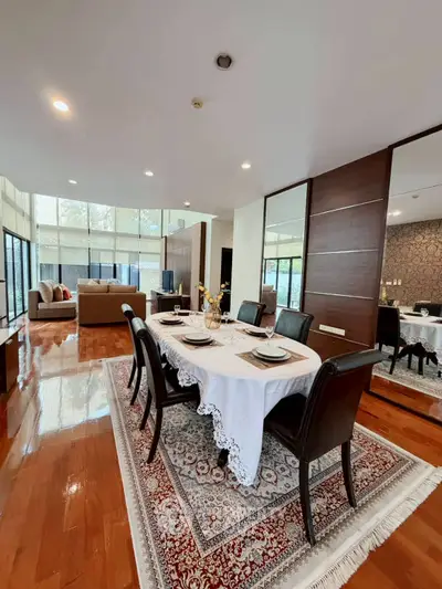 Spacious open-plan living and dining area with elegant decor and large windows.