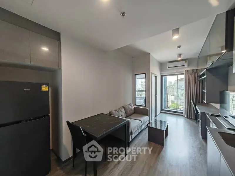 Modern living room with sleek kitchen and city view balcony in urban apartment