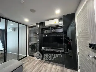 Modern living room with sleek black entertainment center and glass partition