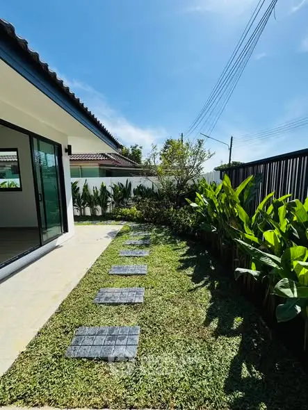 Charming garden view with lush greenery and modern pathway in a serene residential area.