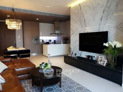 Luxurious modern living room with marble wall, leather sofa, and open kitchen layout.