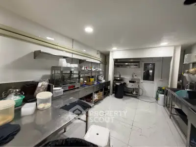 Spacious commercial kitchen with stainless steel countertops and modern appliances