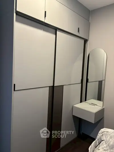 Modern bedroom with sleek built-in wardrobe and stylish vanity mirror