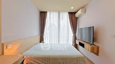 Modern bedroom with large window and city view, featuring a wall-mounted TV and air conditioning.