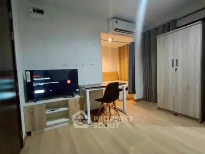 Modern study room with desk, chair, TV, and wardrobe in a cozy apartment.