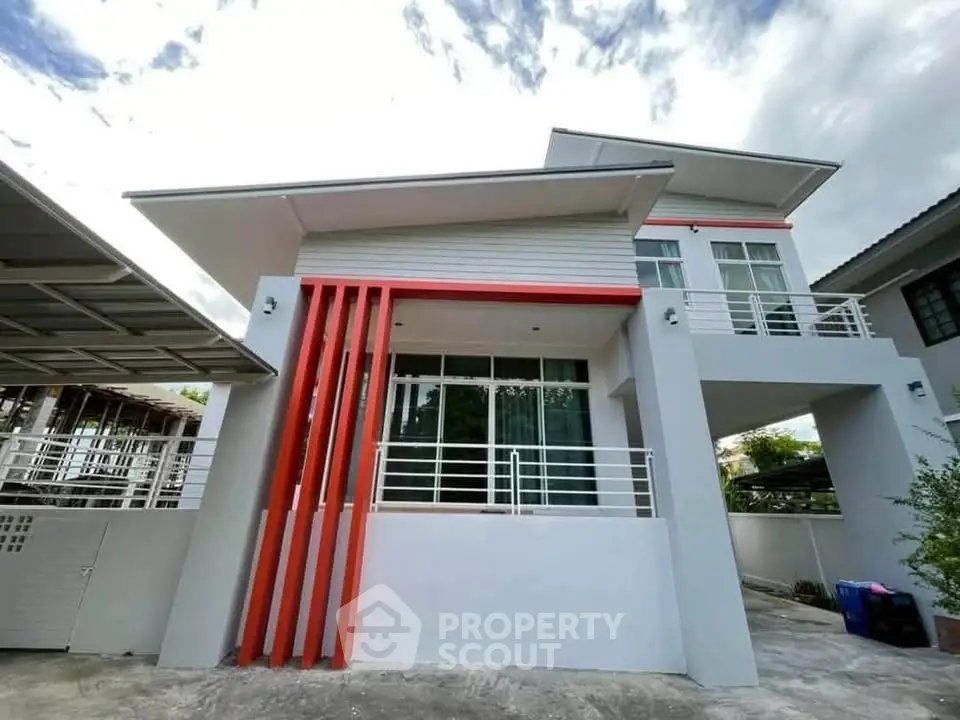Modern two-story house with unique architectural design and spacious balcony.
