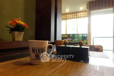 Cozy dining area with a view, featuring a stylish mug and vibrant flowers.