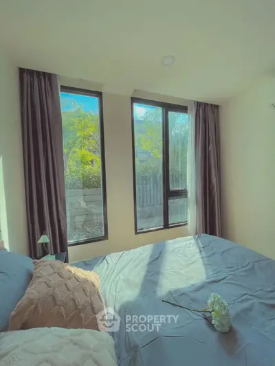 Cozy bedroom with large windows and natural light