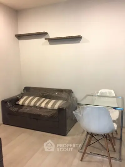 Modern living room with sleek sofa and glass dining table, perfect for urban living.