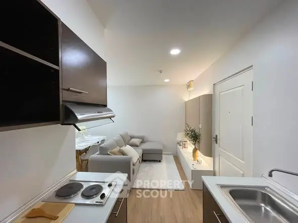Modern open-layout kitchen and living room with sleek design and cozy ambiance.