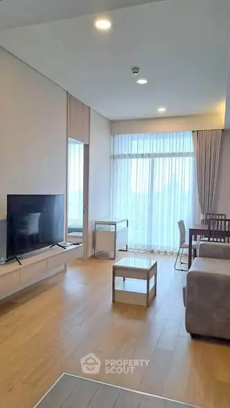 Spacious modern living room with large windows and elegant furnishings.