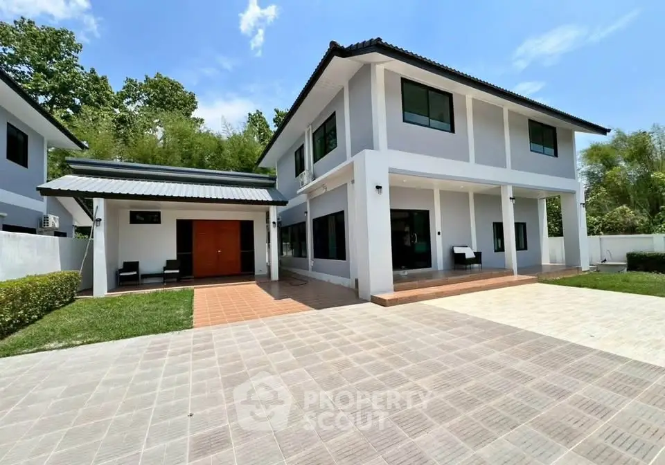 Modern two-story house with spacious driveway and lush greenery