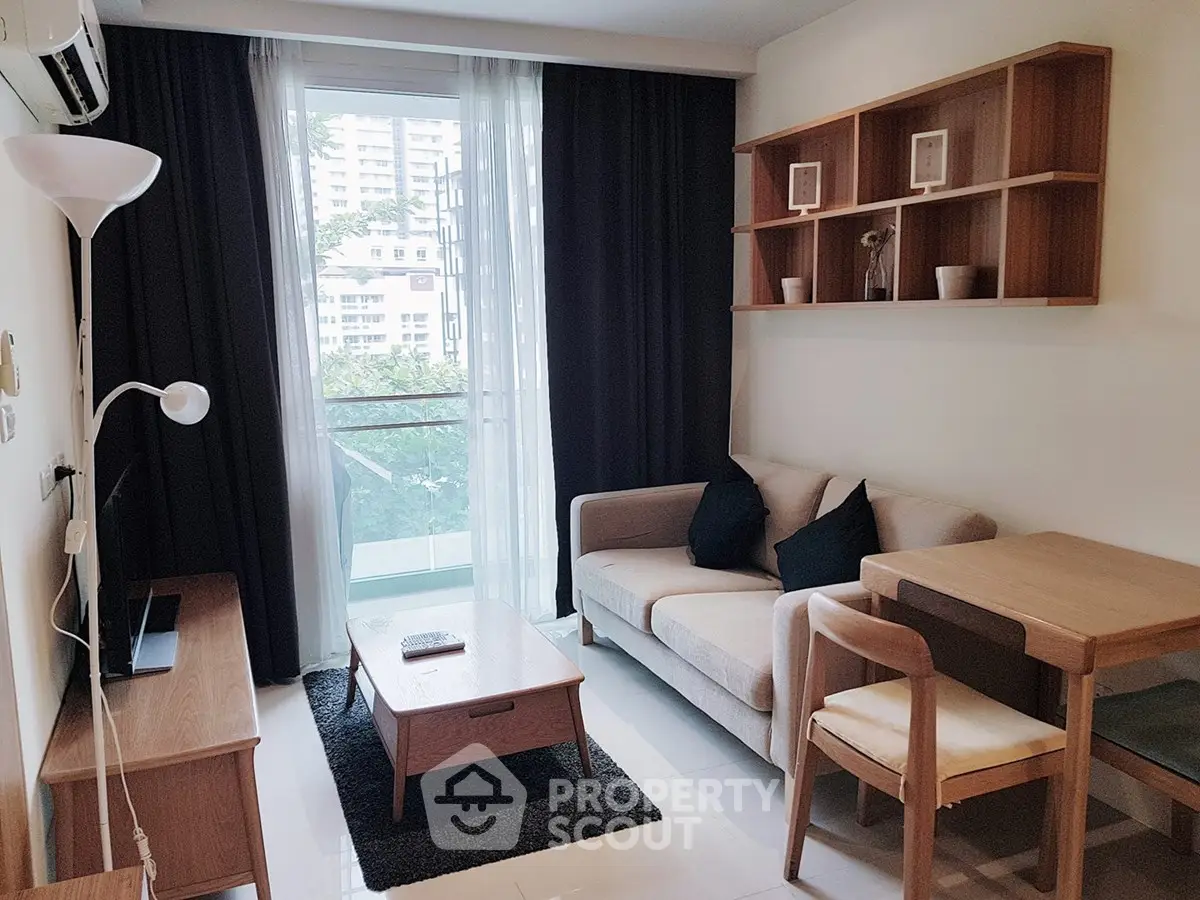 Modern living room with cozy sofa, stylish furniture, and balcony view in a contemporary apartment.