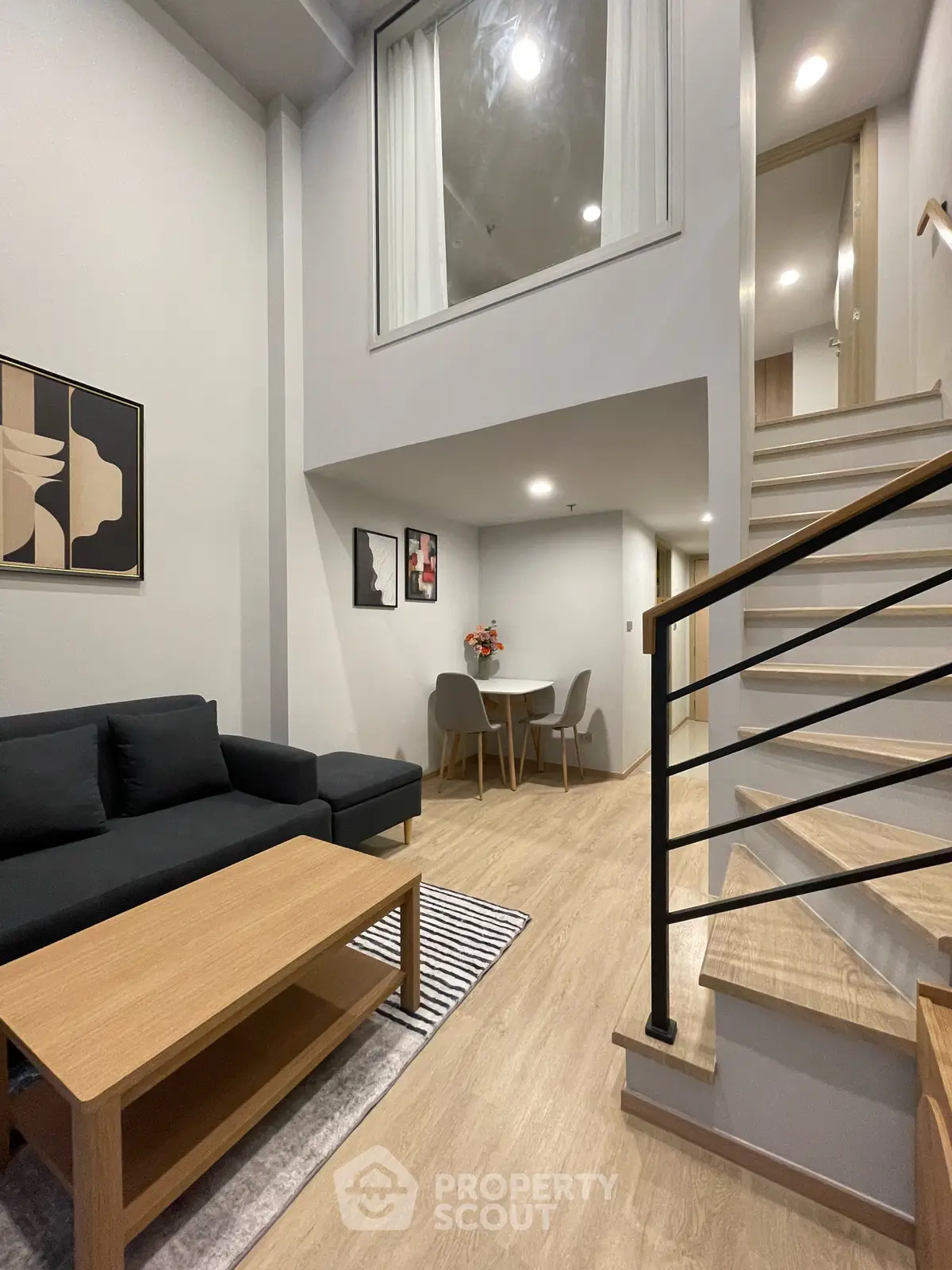 Modern duplex living room with stylish decor and open staircase