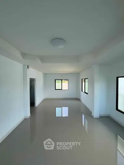 Spacious empty room with large windows and glossy tiled floor, perfect for customization.