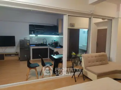 Modern open-layout living and kitchen area with stylish furniture and sleek design.