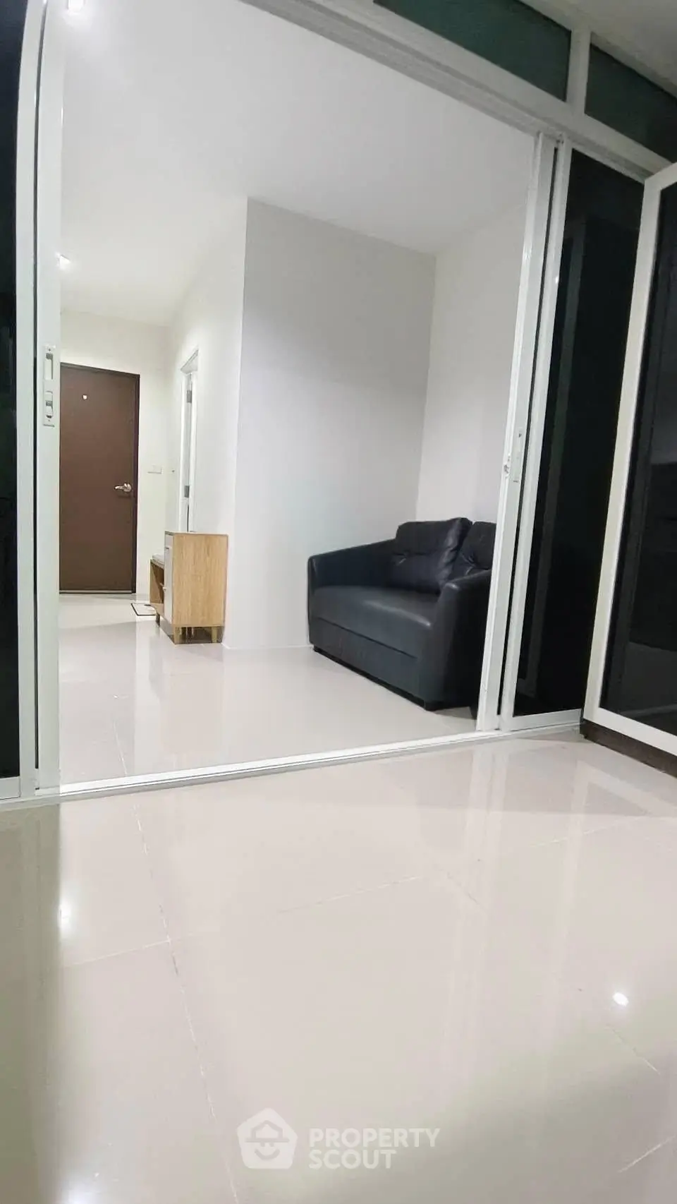 Modern apartment entrance with sleek flooring and cozy seating area.
