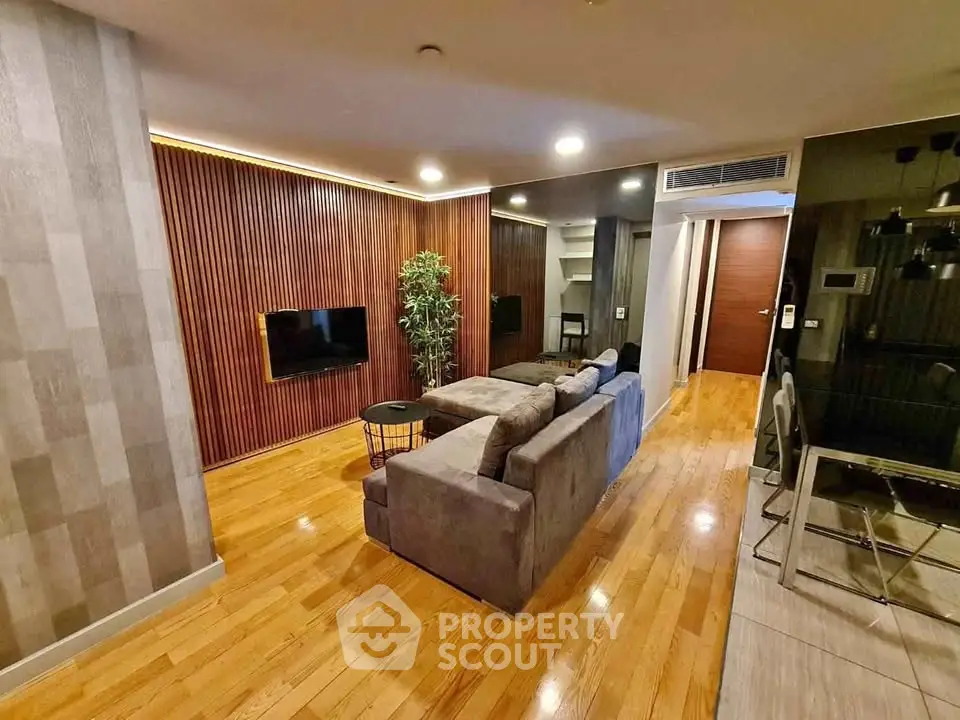 Modern living room with stylish wood paneling and cozy gray sofa