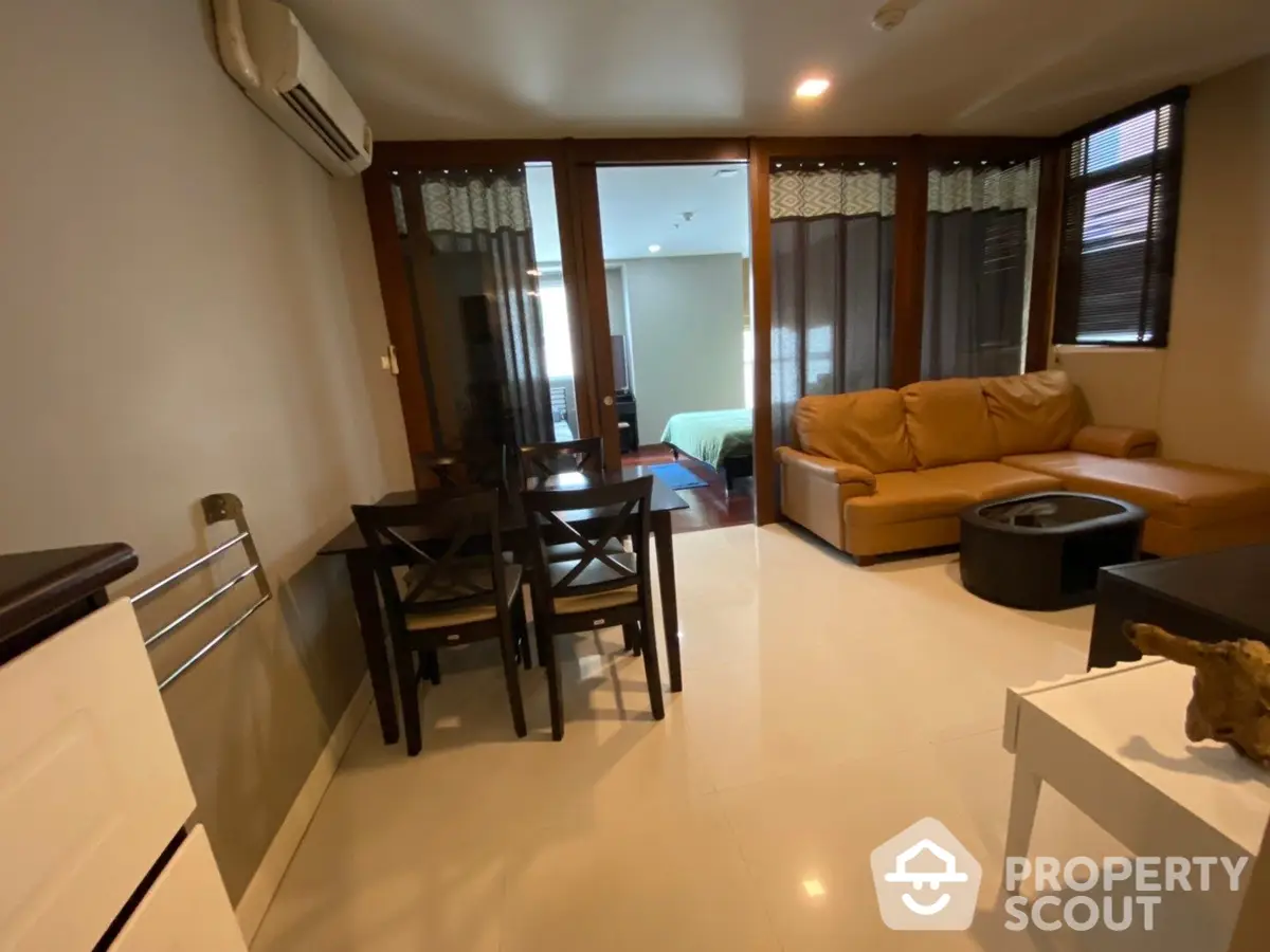 Spacious and inviting living area with glossy tiled floors, modern furniture, and ample natural light from large windows, perfect for urban living.