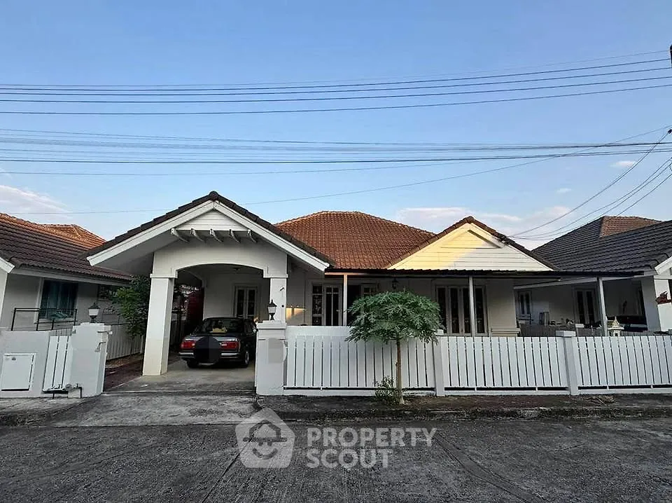 Charming single-story house with carport and white picket fence in a serene neighborhood.
