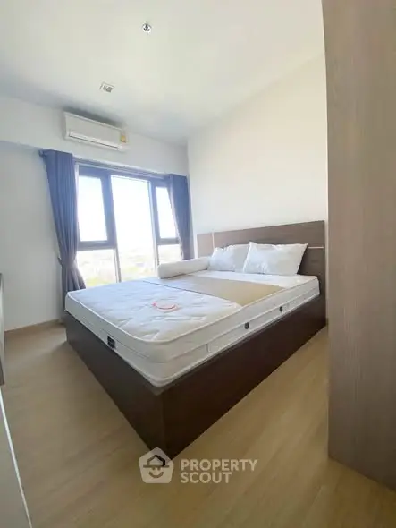 Bright and cozy bedroom with large windows and modern furnishings.