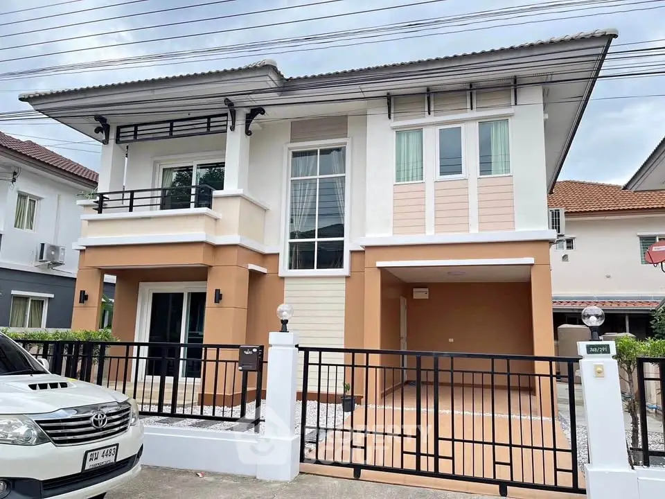 Modern two-story house with stylish facade and gated driveway in suburban neighborhood.