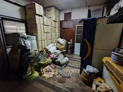 Spacious storage room with wooden floors and stacked boxes, ideal for organizing supplies.