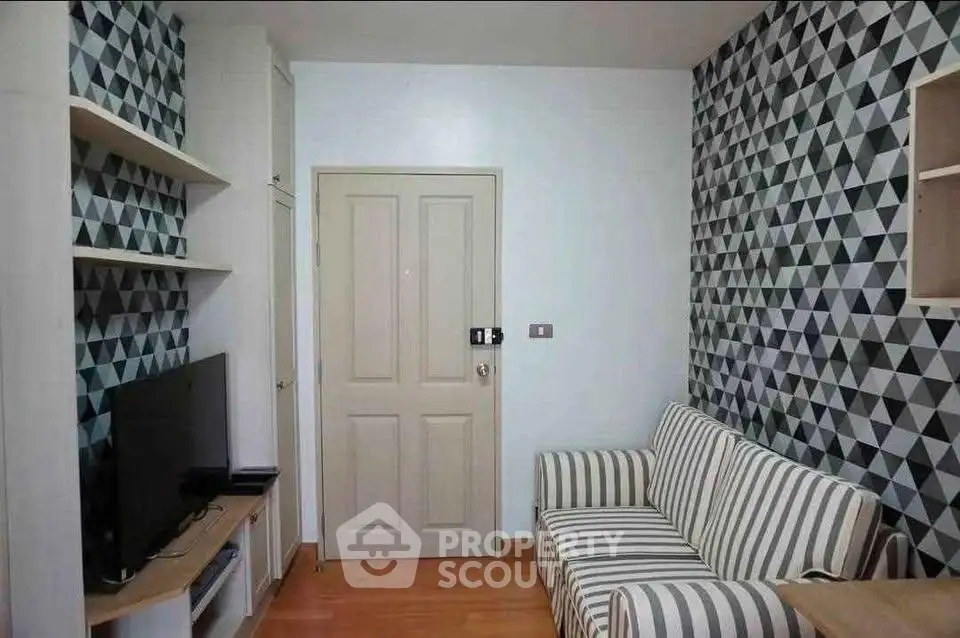 Stylish living room with geometric wallpaper and striped sofa, perfect for modern urban living.
