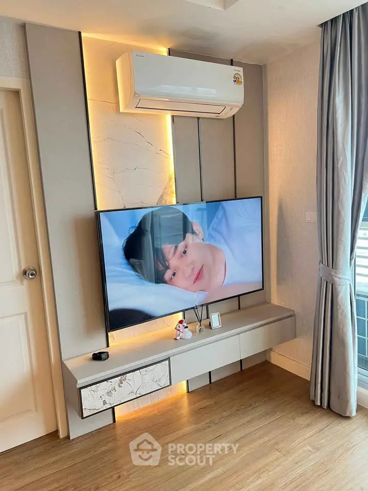 Modern living room with mounted TV and air conditioning unit, stylish decor