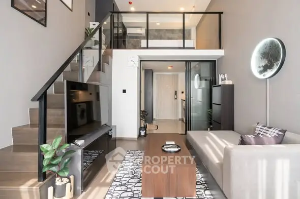 Modern living room with loft design, sleek staircase, and stylish decor in a contemporary apartment.