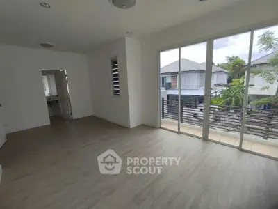 Spacious living room with large windows and balcony access in modern home