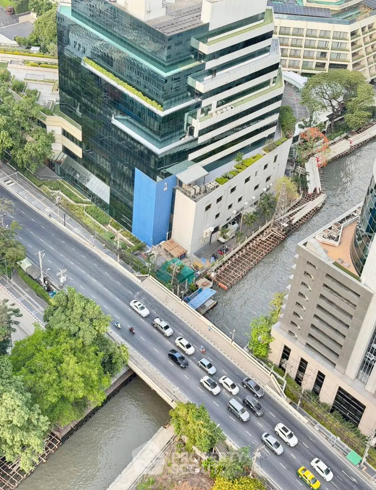 Stunning aerial view of modern office buildings by a canal, showcasing urban architecture and vibrant city life.