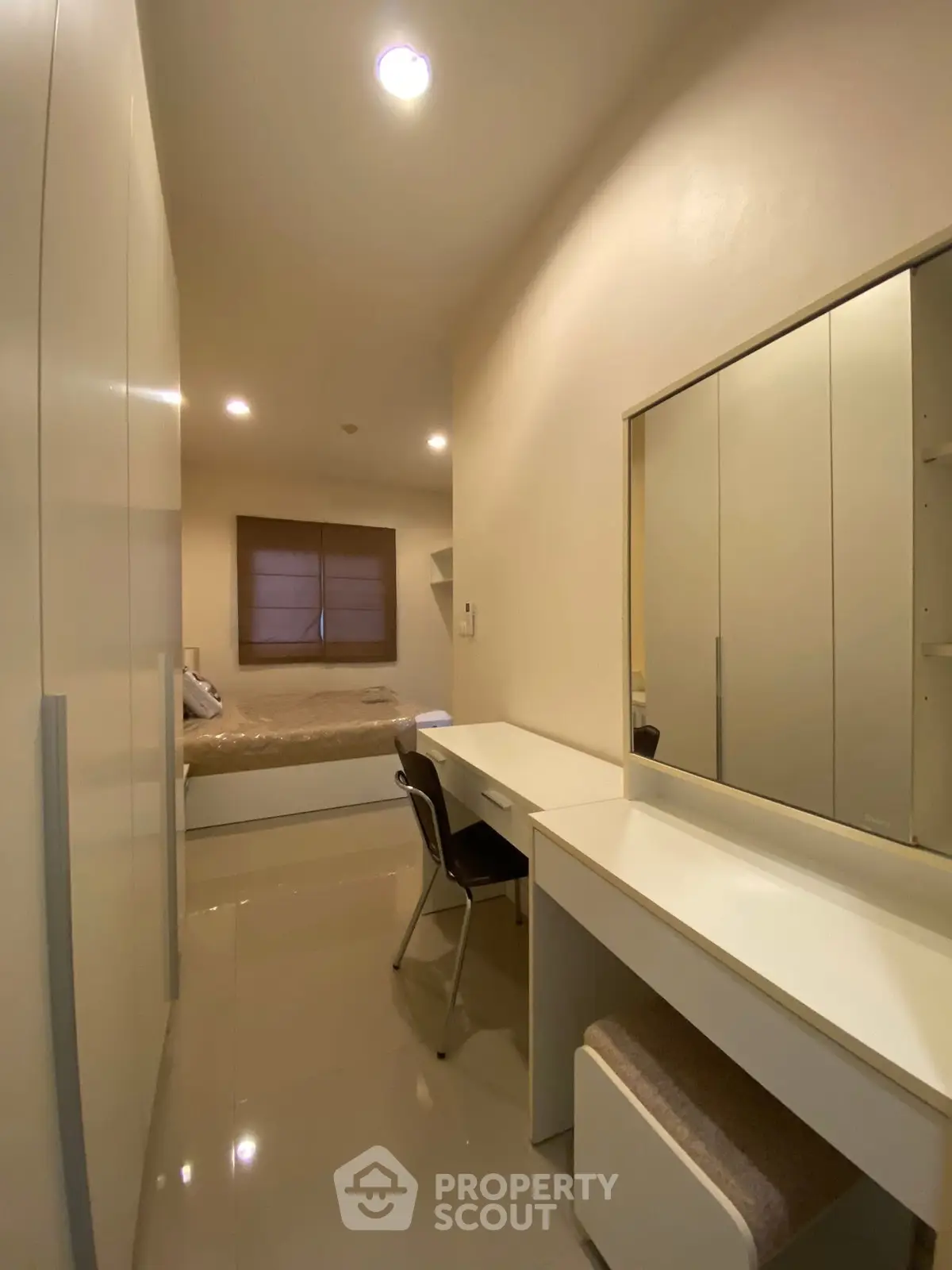 Modern bedroom with sleek furniture and built-in wardrobe, perfect for urban living.