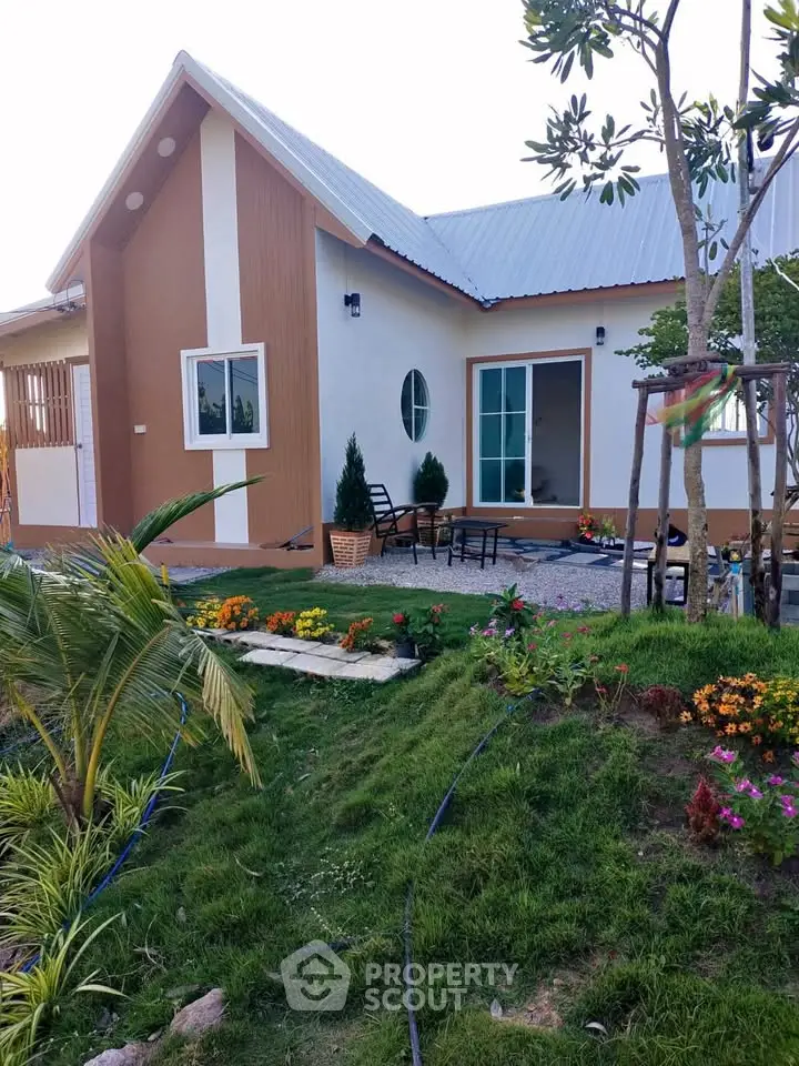 Charming modern house with lush garden and inviting patio, perfect for serene living.