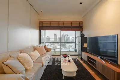 Modern living room with city view, cozy sofa, and large TV