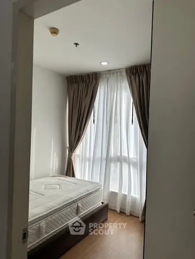 Cozy bedroom with natural light and elegant curtains