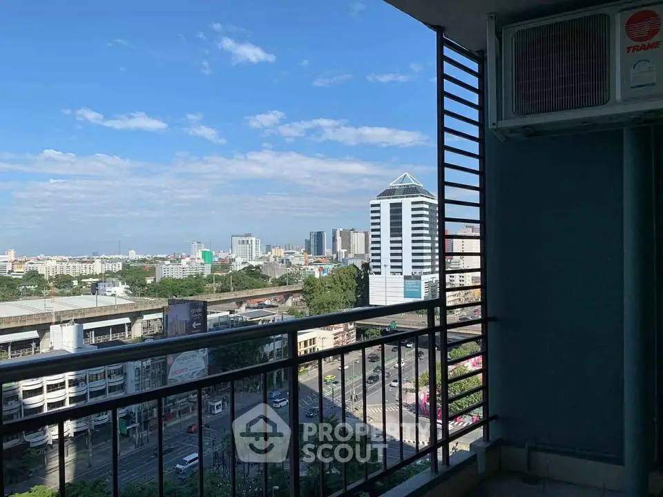 Stunning city view from a high-rise balcony with clear blue skies.