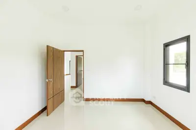 Minimalist empty room with wooden door and window, bright and spacious.