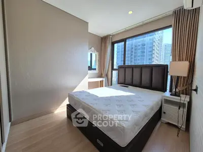 Modern bedroom with large window and city view, featuring a stylish bed and elegant decor.