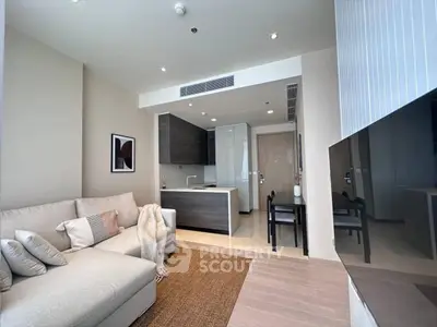 Modern living room with open kitchen layout and cozy sofa in stylish apartment.