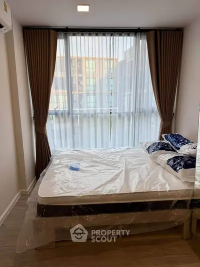 Modern bedroom with large windows and elegant curtains in a stylish apartment.