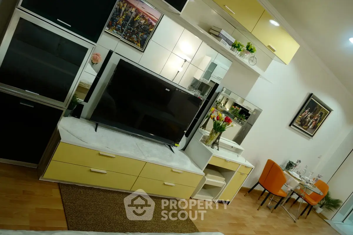 Modern living room with stylish furniture and dining area, featuring a sleek TV setup and vibrant decor.