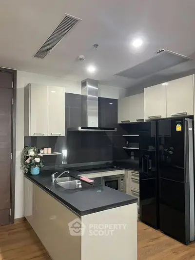 Modern kitchen with sleek black appliances and stylish cabinetry in a contemporary home.