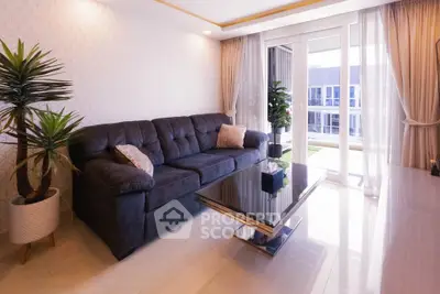 Modern living room with plush sofa and balcony view, perfect for relaxation and entertaining.