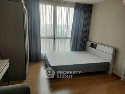Modern bedroom with large window and stylish furniture in a high-rise apartment.
