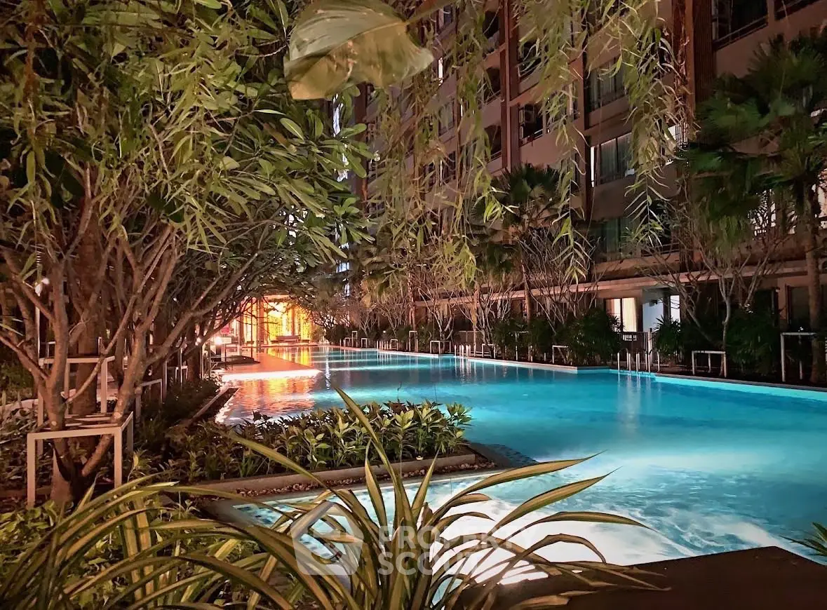 Luxurious residential pool with ambient night lighting and lush greenery