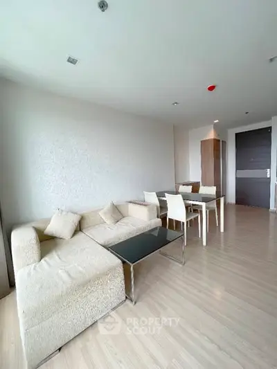 Spacious modern living room with elegant furniture and dining area in a bright apartment.