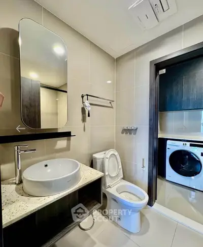 Modern bathroom with sleek fixtures and in-unit laundry for convenience.