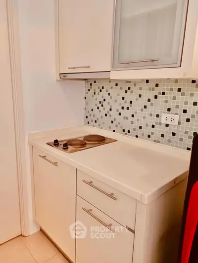 Compact kitchen with electric stove and modern backsplash tiles